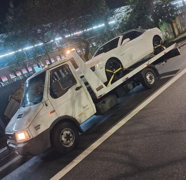 Guincho transportando um carro branco durante a noite