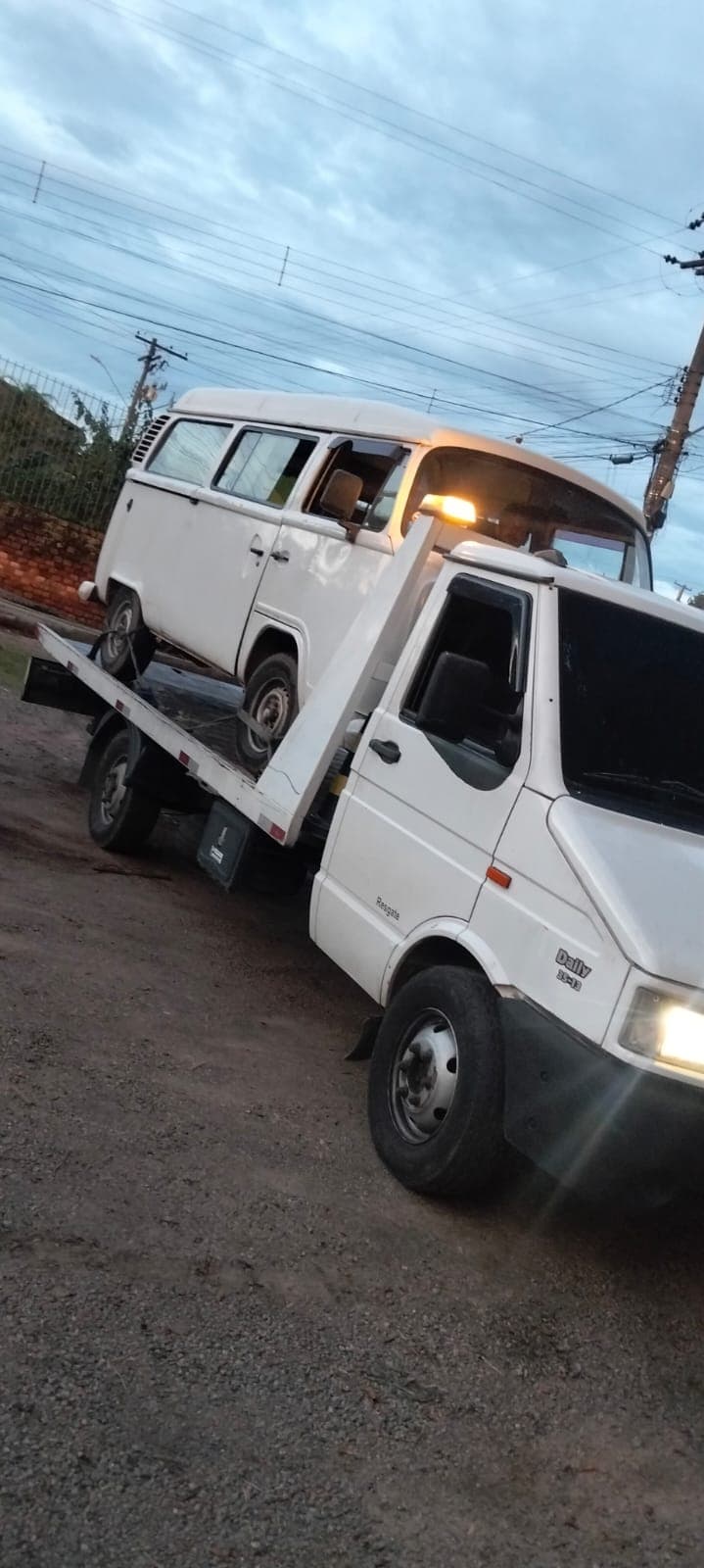 Guincho plataforma transportando uma Kombi